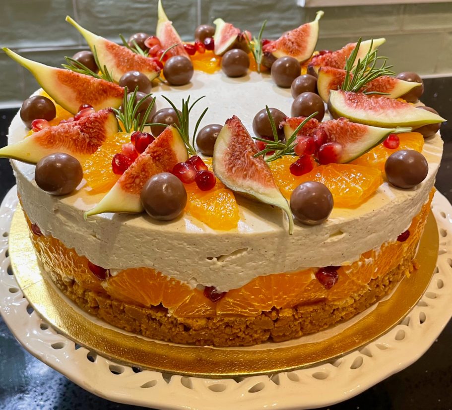 Seasonal spiced cheesecake decorated with oranges, fig slices, pomegranate and chocolate Seasonal spiced cheesecake decorated with oranges, fig slices, pomegranate and chocolate