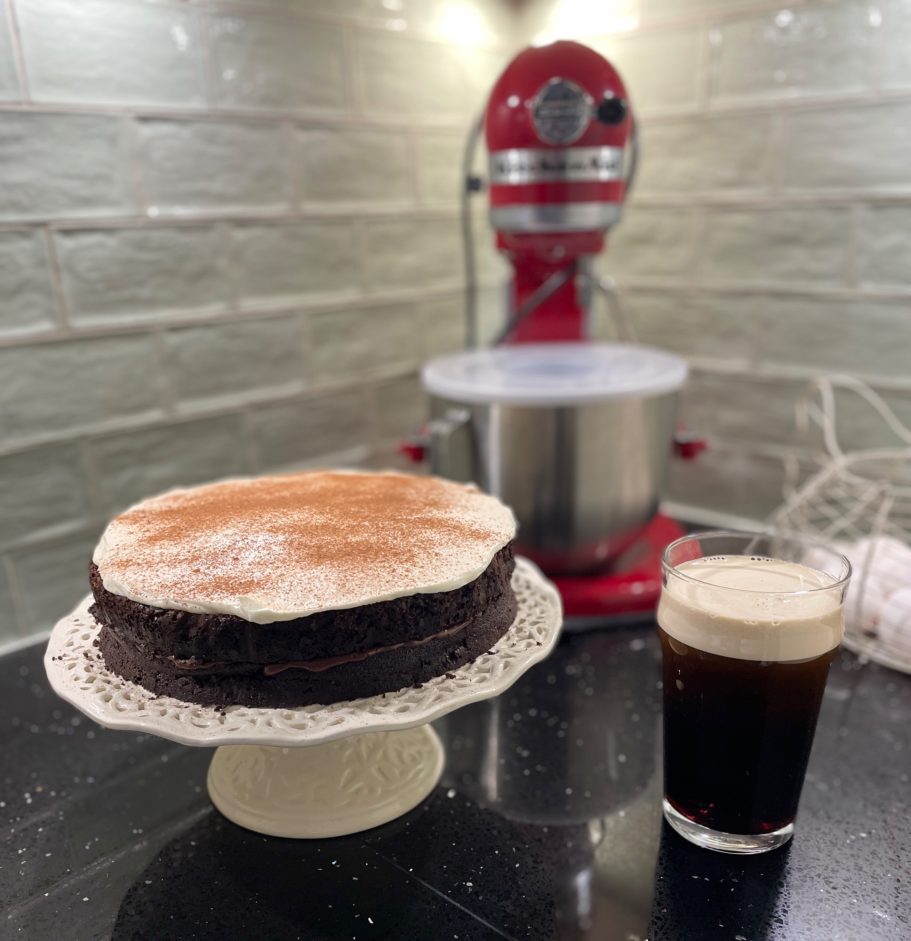 Chocolate Guiness cake with cream frosting next to pint of Guiness Chocolate Guiness cake with cream frosting next to pint of Guiness